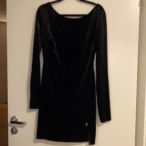 Sammetsklänning, storlek L - Fin svart sammetsklänning, med en slits på sidan. Oanvänd, bara testad. Prislappen sitter kvar