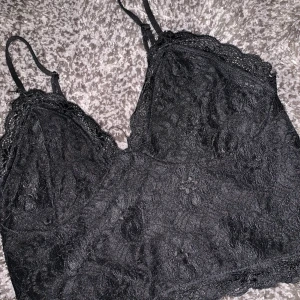 Spets linne - Ett fint svart spets linne, längden är som en magtröja.