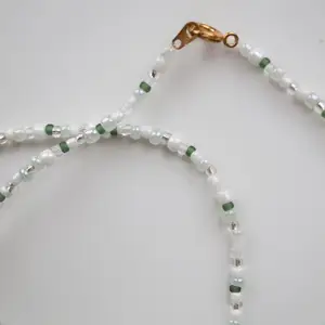 Handgjort halsband i gröna toner.