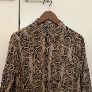  - En ormklänning (kort-modell) som funkar som större skjorta eller klänning. Går att klippa av om man vill ha den som kort skjorta istället. Står strl L men passar en M, eller en S.