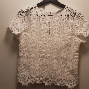  - Kortare topp i fin vit spets och medsytt linne. Blixtkedja baktill. 34 som storlek men funkar även på mig som snarare har 36-38 på toppar. Riktigt söt till jeans på sommaren!