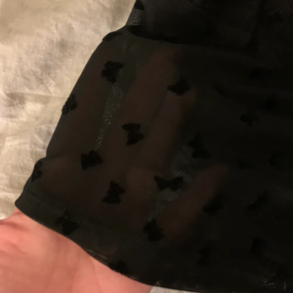 Säljer ett cropped mesh linne med fjärils detaljer från märket MOTEL, har bara använt den 1 gång och har inte haft användning av den sen dess✨ modellen på bilden har storlek small✨ frakt tillkommer . Toppar.