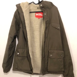 KNAPPT ANVÄND FJÄLLRÄVEN JACKA  - Hej, jag säljer nu en Fjällräven jacka då den tyvärr inte passar längre. XS men sitter som S. Perfekt inför vår/hösten. Nypris på jackan ligger runt 2000kr. Skicket skulle jag säga är 8/10, då den är varsamt använd! Vid BIN kan jag stå för frakten annars står köparen för fraktkostnaden! :)