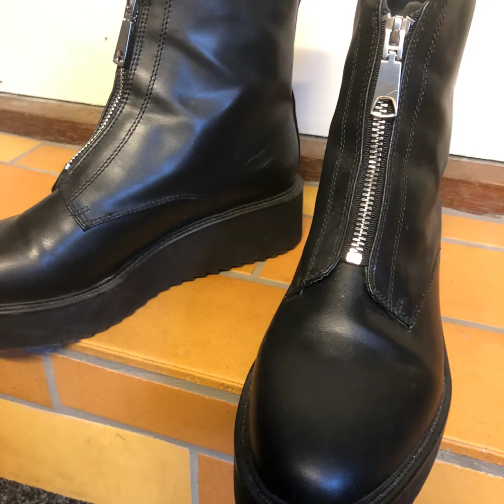 Svarta läderimitation boots med dragkedja fram och med lite platå sula. Använd ett fåtal gånger så de är i nyskick!. Skor.