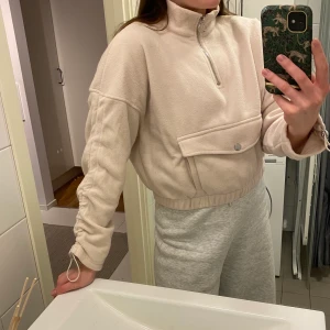 Fleece sweater - Gräddvid fleecetröja med dragkedja framtill från Bershka. Använd 1 gång. Mycket bekväm, croppad modell. Storlek L men skulle säga att den är mer som en M. 