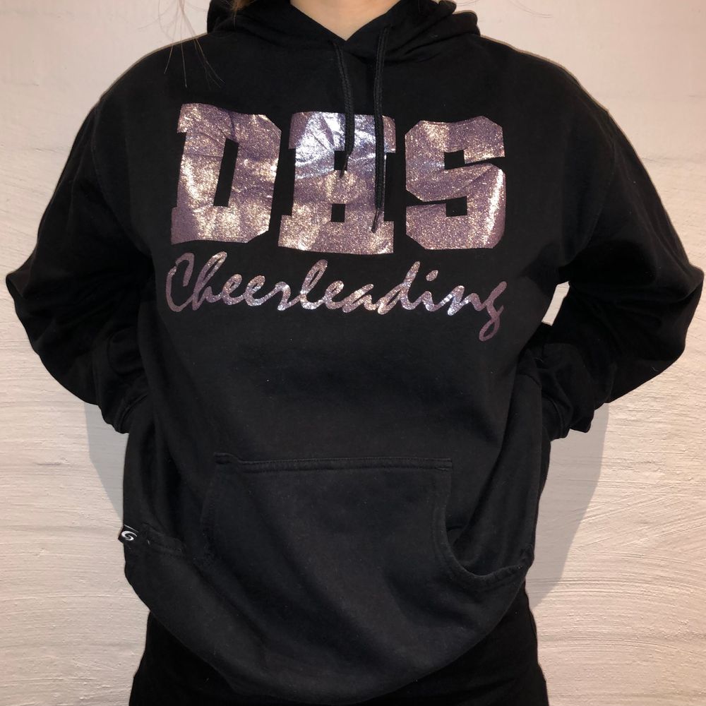 Dags för andra släppet! Vi säljer denna svarta hoodie med ett glittrig tryck på den. De står DHS Cheerleading. Priset är 279kr. Den är i storlek XL och sitter som en L/XL. Personen på bilden är 165cm och brukar ha på sig M. Inga defekter på hoodien. Kontakta oss på Plick eller vår Instagram @wanderetro. Om flera visar intresse blir det budgivning. Köparen står för spårbar frakt på 66kr. 🤍. Huvtröjor & Träningströjor.