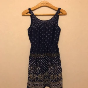  - Mörkblå kort klänning från H&M med spännande mönster. Fin rygg med ett triangulärt hål som ger ett mer intressant utseende. Storlek 34. Frakt tillkommer.