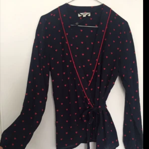  - Omlottblus i marinblått med röda hjärtan. Aldrig använd och har alla etiketter kvar. Köparen står för frakt✨