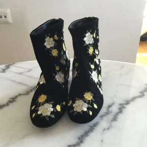  - Ett par sammets skor med broderade blommor på! Aldrig använda! Köparen står för frakt på 90kr 