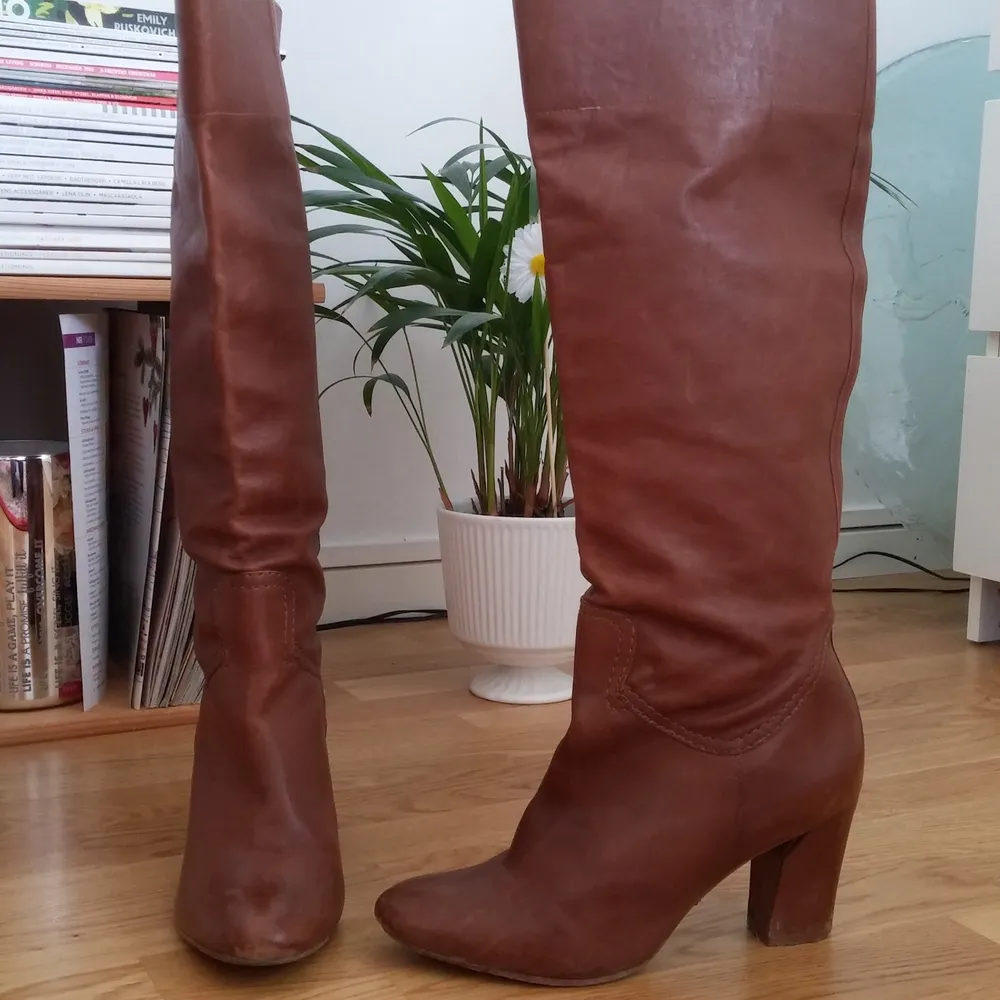 Under the knee boots, very comfortable, in 100% leather. It says size 40, but it feels like a 39 because it is a bit tight around the finger toes (I wore them with a pair of socks).  The boots are in good condition, with some scratches.. Skor.