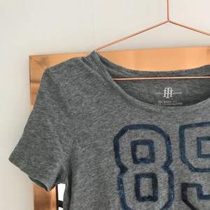 Grå T-shirt från Tommy Hilfiger med mörkblå text, köpare står för frakt😋