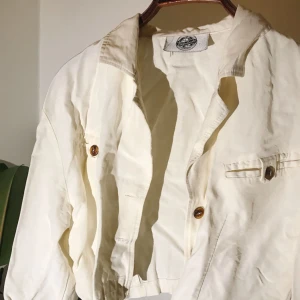  - Snygg vit/cremefärgad kort jacka från Vagabond från ca 80-talet. Den har fina bruna knappar :)