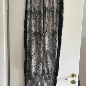 Coolaste snake byxorna - Skitcoola byxor i snake mönster av märket ” Noisy may”. Lite glansiga i tyget. Dragkedjor längst ner.   Nyskick, använda en gång. Betalas med swish. Frakt ca 50:- 
