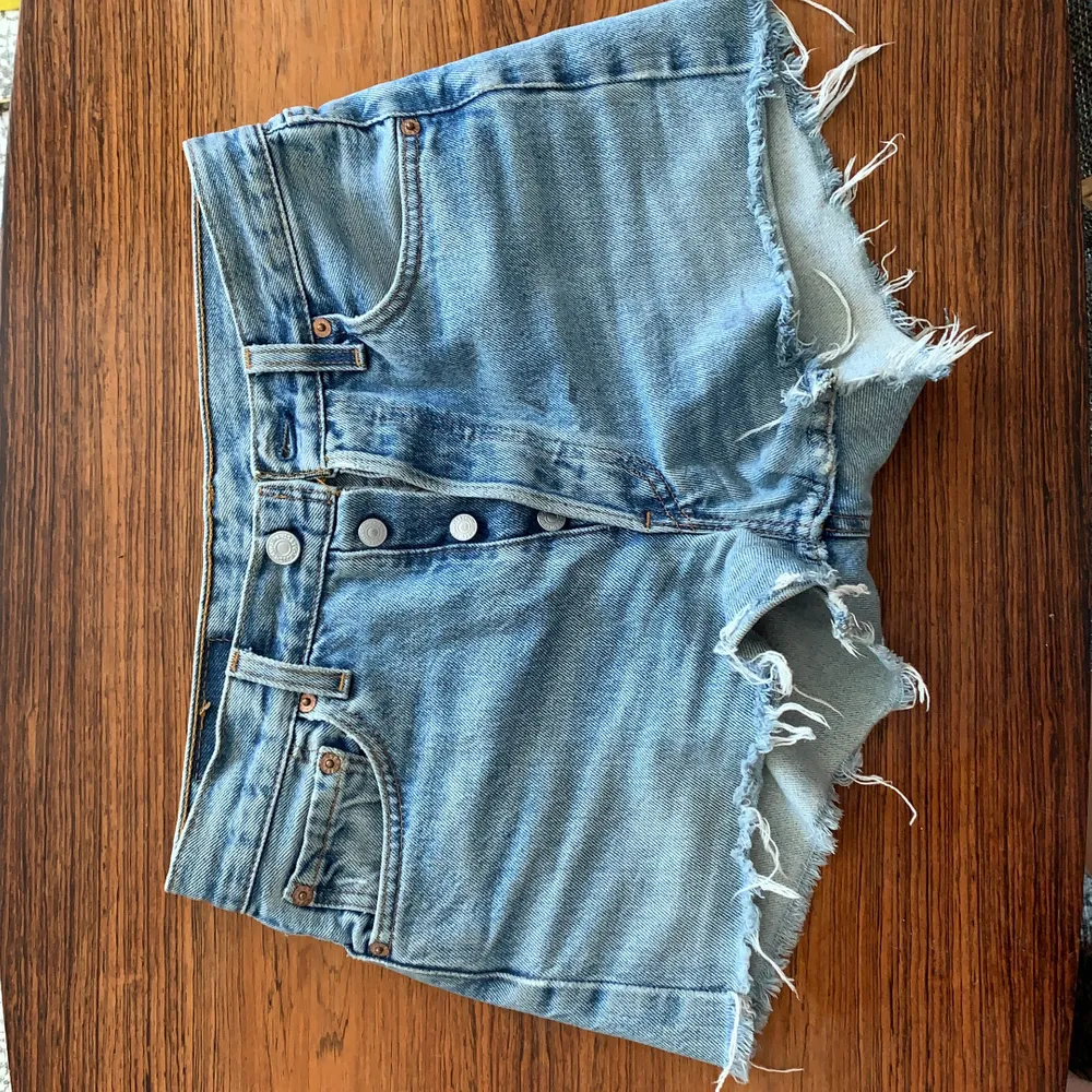 Ljusblå Levis shorts med knapp gylf köpta på Emmaus för 400 kr. Midjemått: 75 cm/W29. Storlek small. Har två knappt märkbara små fläckar som visas på bilderna. (Läs i profilen om du är intresserad<3). Shorts.