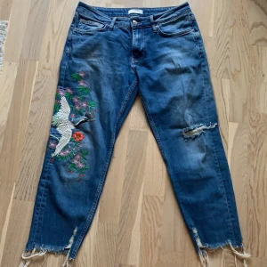 Jeans från ZARA - Blåa jeans från ZARA med slitningar och fint broderi. Använda 1 gång så de är så gott som nya. Fraktavgift tillkommer, kan även mötas upp i Uppsala. 