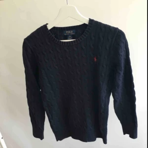  - Navyblå kabelstickad tröja från ralph lauren i storlek L junior 14-16 år. Använt men fint skick, säljes då den blivit för liten. 