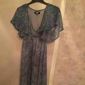  - Ljusblå mönstrad Långklänning! Jätte fin nu till sommaren! Sval och mjuk. Använd 1 gång. 