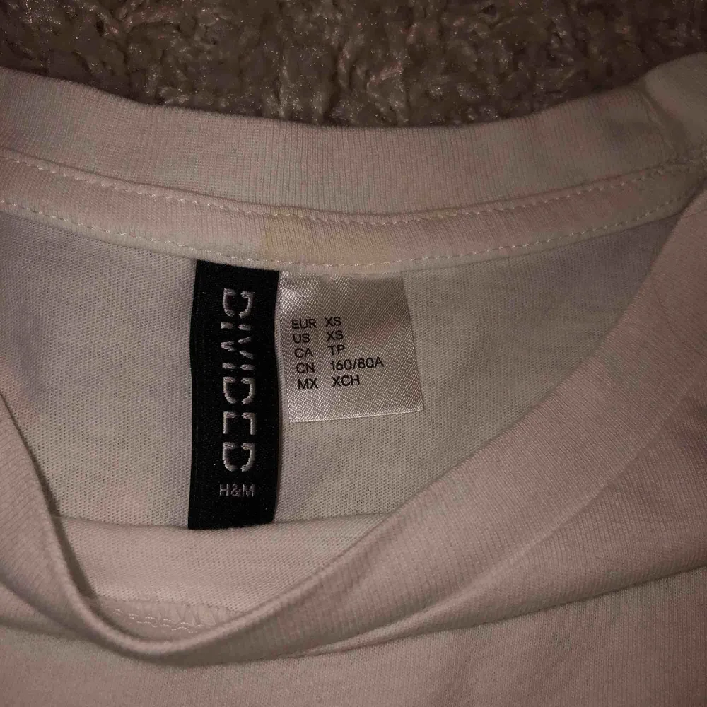 Kortärmad tröja från h&m med detalj. En fläck vid storleks lappen men inget som syns tydligt. Aldrig använd. Köparen står för frakt.. T-shirts.