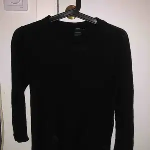En svart tröja med öppning bak 