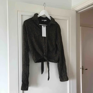  - Chiquelle storlek M magtröja i grön leopard. Knytes i midjan. Frakt 30 SEK 