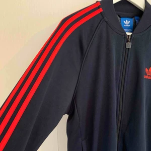  - En mörkblå adidas crewneck med röda stripes! Superfint skick, endast använd 1 gång, köpt i USA! 