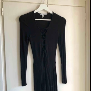  - Svart klänning från Nelly.com med snördetaljer vid brösten. Storlek S. Köparen står för frakten 