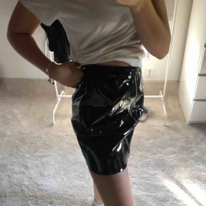  - Säljer denna svarta lack kjol från boohoo. Den är endast testad, lappen är kvar i. Jag är en storlek 34-36 o den sitter ganska pösigt på mig. Så som du  vill att den ska sitta tightare skulle jag rekommendera denna kjol för en 36/38! Frakt ca 30kr. 