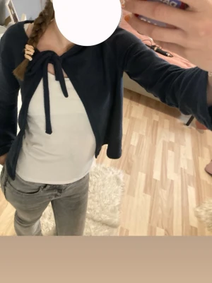 Marinblå kofta med rosett från lager157 - En söt marinblå kofta som är köpt på barnavdelningen på lager157 men passar mig som då hade S/170 i de flesta kläderna. Storleken är 160 men det är typ som 170. Koftan är i bra skick och har inte används mycket. Skriv gärna vid frågor!