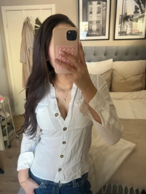 Vit skjorta med knappar - Klassisk vit skjorta med v-ringning och snygga knappar framtill. Lite skrynklig men annars i toppen skick!!! 💕💕💕💖✨😚🥰