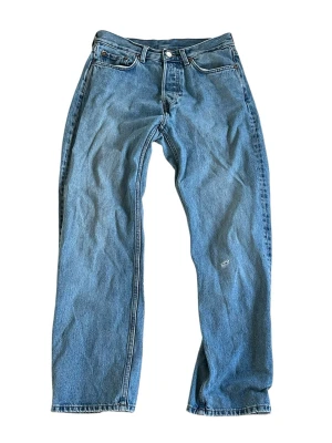 Weekday jeans - Klassiska blå jeans från weekday med rak passform och fem fickor. Jeansen har en ljus tvätt och är tillverkade i slitstark denim. Läderpatch med logga baktill i midjan och metallknapp framtill. Perfekta för en avslappnad och tidlös stil. Modell: space relaxed straight jeans. Storlek 28/30.