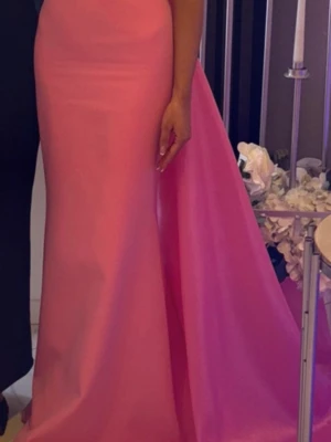 Lång rosa balklänning i satin - Säljer denna eleganta, figurnära långklänning i en vacker rosa nyans 💗 Axelbandslös modell med stilren passform och fin detalj baktill som ger ett lyxigt intryck. Perfekt till bal, bröllop eller fest.  Hör av dig vid intresse ✨  säljs för 2500, priset kan diskuteras 