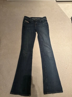 Blå bootcut jeans från diesel - Säljer ett par mörkblå bootcut jeans från diesel med låg midja. Jätte fin mörkblå tvätt