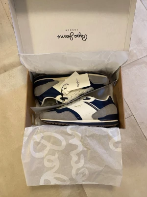 Pepe Jeans sneakers - Hej! Säljer ett par helt nya sneakers av märket Pepe Jeans. Originalboxen finns och alla lappar sitter kvar. Storlek: 43. Nypris: ca 1000 kr+frakt. Perfekta till våren! Tveka inte att höra av dig vid frågor