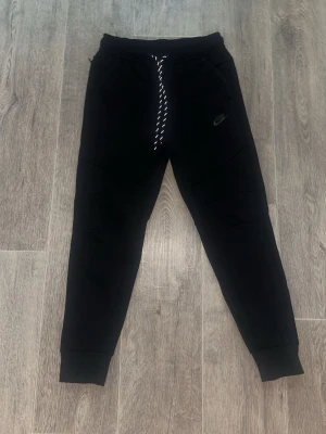 Svarta Nike Tech byxor  - Säljer detta par nike tech byxor oanvända och klockrena. Storlek XS så passar ganska slim.