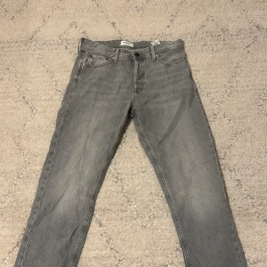Grå relaxed jeans från Jack & Jones - Säljer ett par gråa relaxed fit jeans från Jack & Jones, modell Chris. Klassisk femficksdesign och raka ben. Perfekta för en avslappnad och trendig stil. Jeansen har knappgylf och är tillverkade i mjukt denimtyg. Aldrig använda storlek w31 w32