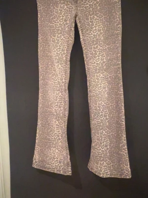 Leopard jeans ifrån Nelly  - Snygga bootcut jeans med beige och ljusbrunt leopardmönster. Jeansen har utsvängda ben och en trendig passform som sticker ut. Perfekta för dig som vill ha ett unikt plagg i garderoben. Materialet känns mjukt och följsamt. Säljer dessa jeans ifrån Nelly, använd 2 gånger så i nyskick. Storlek 36
