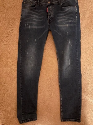 Mörkblå distressed jeans Dsquared2 - Jag säljer ett par 100% äkta Dsquared 2 jeans som jag fuck u födelsedags present. Byxorna var för små för mig och jag sluta använda dem bara efter 2 dagar.Det är ett par Hip-Hop jeans som passar bra i en stilig dag i skolan eller på jobbet. priset kan diskuteras.