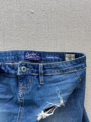 Low wiast jeanskjol med slitningar - Säljer en low waist ripped jeanskjol, prefekt till sommaren/våren. Märket är crocker