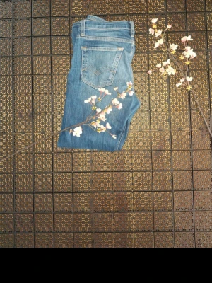 Blå raka jeans från Replay  - Snygga blå jeans från Replay. med klassisk femficksdesign och raka ben. Jeansen har en medelhög midja och subtila slitningar framtill för en avslappnad look. Perfekta till vardagsstilen och lätta att matcha med olika toppar.