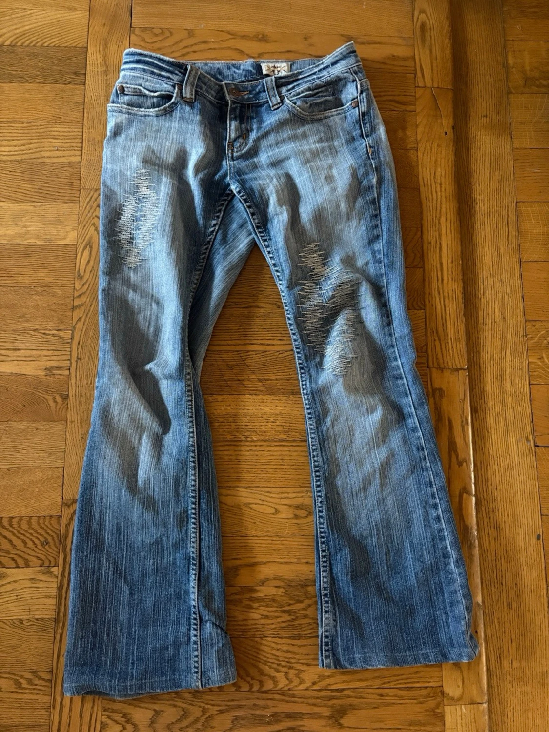 Blå bootcut jeans med slitningar