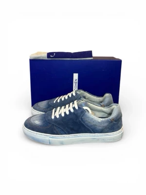 Blå denim sneakers från Jacob Cohën - Snygga sneakers i blå denim från Jacob Cohën med vita skosnören och vit sula. Skorna har en klassisk låg modell och detaljer i olika nyanser av blått. Perfekta för dig som gillar en avslappnad men trendig stil.