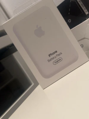 Apple MagSafe iPhone Battery Pack - Säljer ett Apple MagSafe Battery Pack till iPhone. Den är vit och har en stilren, kompakt design med rundade hörn. Perfekt för att ladda din iPhone trådlöst när du är på språng. Passar alla iPhones med MagSafe-stöd.