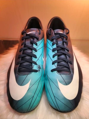 Nike Mercurial Victory AG - Nike Mercurial Victory AG | Blue & Turquoise.   Skick: 6,5/10 Storlek: 45 Produktkoden: 396122-413  Det finns Två defekter en på framsidan och den andra på sidan " Kolla sista bilden " Annars skorna i sig är i väldigt bra skick.