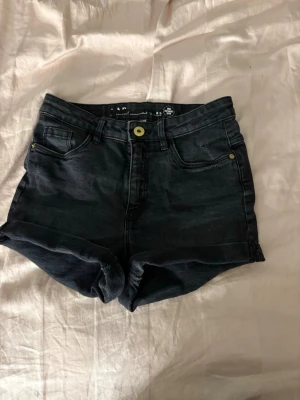 Mörkgrå jeansshorts  - Gråa/svarta jeansshorts med medelhög midja. Storlek 152 men sitter som xs ungefär!