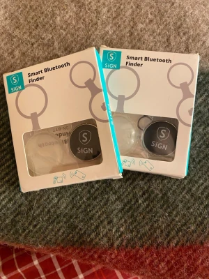 SiGN Smart Bluetooth Finder - Två OANVÄNDA smarta Bluetooth-finders från SiGN, perfekta för att hitta nycklar eller mobil. Svart rund design i plast, levereras i originalförpackning. Säljer båda för 80kr. NY PRIS= 99kr /st 