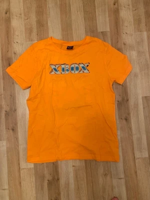 Xbox T-shirt - Säljer denna T-shirten för att den inte kommer till användning. Den är oanvänd och har legat i ett skåp i flera månader. Skriv vid funderingar. 