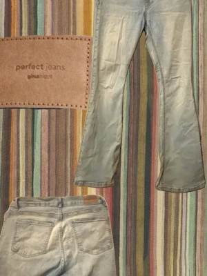 Ljusblå bootcut jeans från Gina Tricot - Säljer ett par ljusblå bootcut jeans från Gina Tricot, modellen 'perfect jeans'. Jeansen har klassisk femficksdesign, normal midja och utsvängda ben. Perfekta för en avslappnad och trendig look.Dom är lite slitna på Byxbenets nederkant.