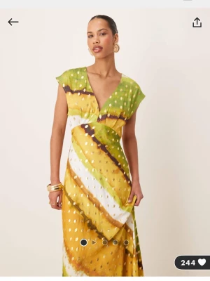 Grön och gul långklänning med v-ringning - Never fully dressed - Långklänning med v-ringad hals och korta ärmar. Snygg passform som markerar midjan. Aldrig använd. 