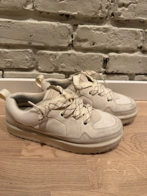 Beige sneakers från UGG med snörning - Säljer ett par snygga beige sneakers från UGG med chunky sula och breda snören. 