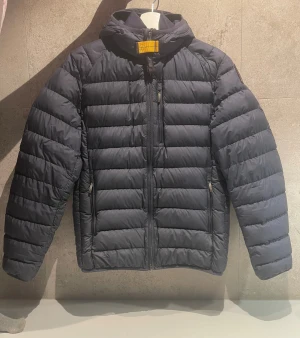 Marinblå Parajumper dunjacka storlek XS -   Säljer min mörkblå dunjacka från Parajumper i storlek XS i man-storlek. Nypris 4599kr på parajumpers hemsida. Två framfickor två innerfickor och en bröstficka. Den har den trendiga parajumper loggan på vänster ärm. Skulle säga att skicket på den är 8/10 Skanna QR koden på bild 6 för att komma till parajumpers hemsida.